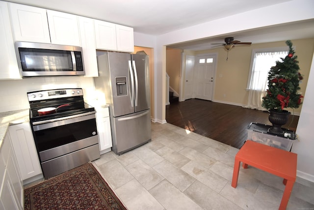 kitchen featuring tasteful backsplash, ceiling fan, white cabinets, and appliances with stainless steel finishes