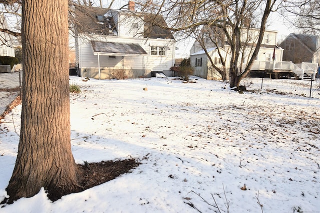 snowy yard featuring a wooden deck