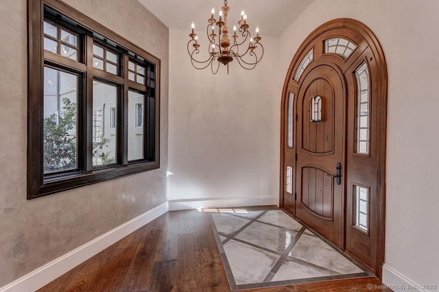 foyer entrance featuring wood-type flooring and a chandelier