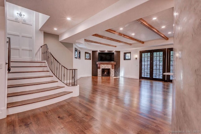 unfurnished living room featuring french doors, wood-type flooring, and beamed ceiling
