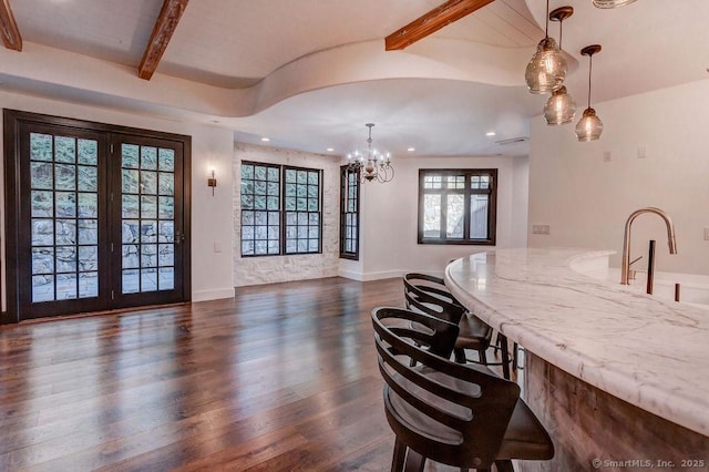 dining room featuring dark hardwood / wood-style floors, a chandelier, sink, and beam ceiling