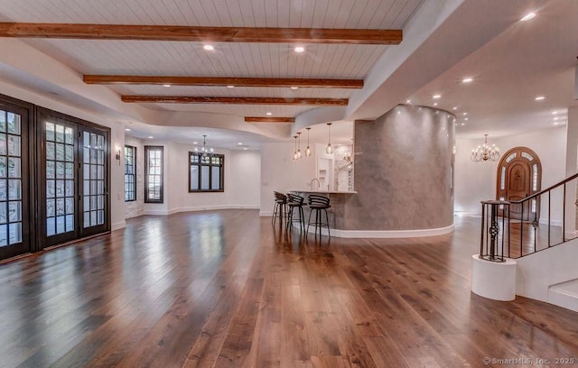 living room with beamed ceiling, dark wood-type flooring, wood ceiling, and an inviting chandelier