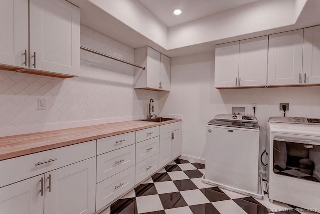 laundry room featuring sink, cabinets, and washing machine and clothes dryer