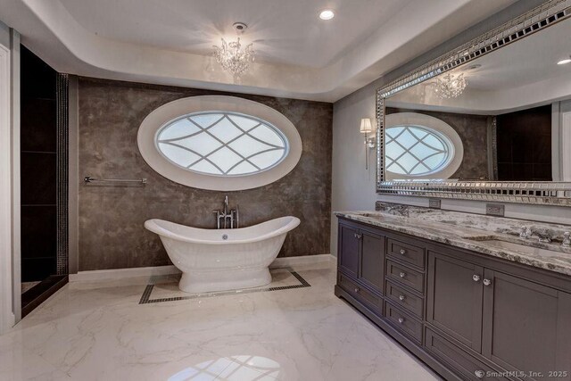 bathroom with vanity, a bathtub, and a tray ceiling