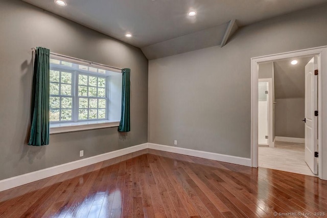 empty room featuring vaulted ceiling and light hardwood / wood-style floors