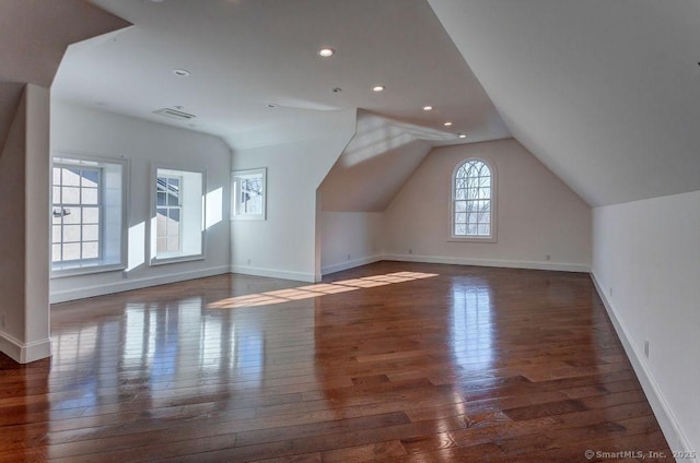 additional living space featuring dark wood-type flooring and lofted ceiling