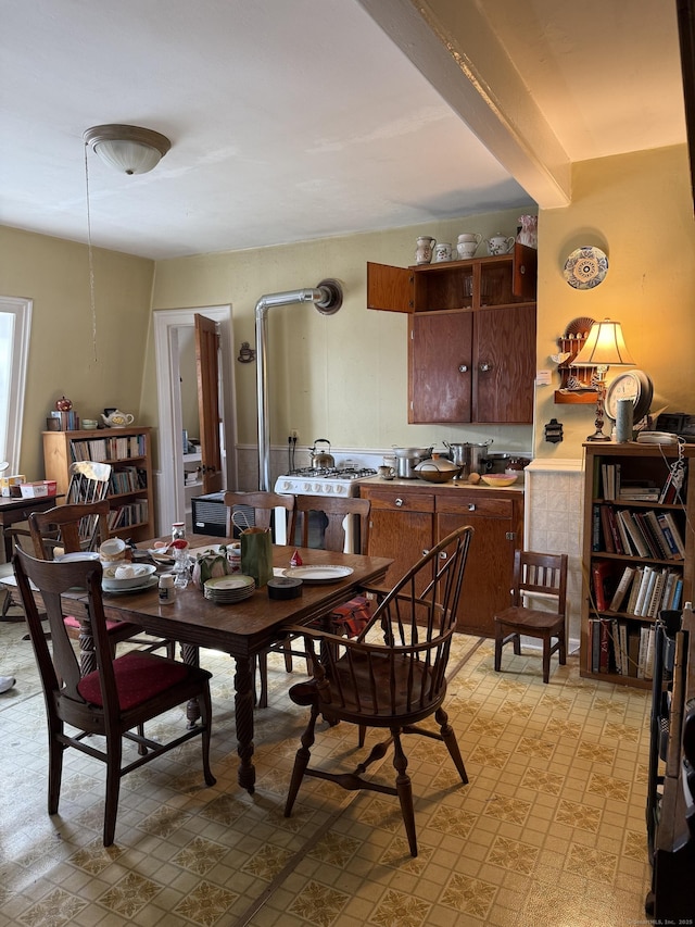 dining space featuring beam ceiling