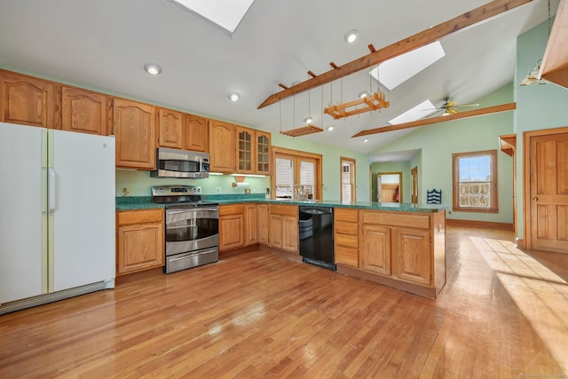 kitchen with pendant lighting, stainless steel appliances, vaulted ceiling with skylight, kitchen peninsula, and light wood-type flooring