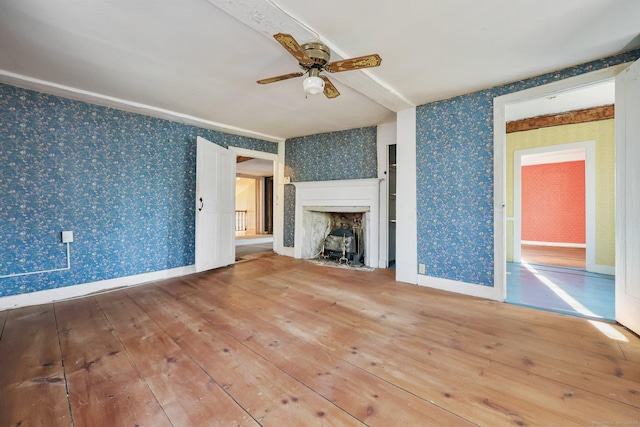 unfurnished living room with hardwood / wood-style flooring and ceiling fan