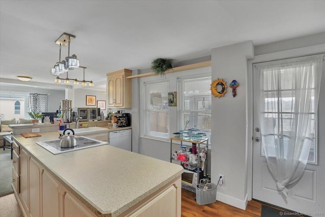 kitchen featuring light wood-style floors, light countertops, dishwasher, light brown cabinetry, and stovetop