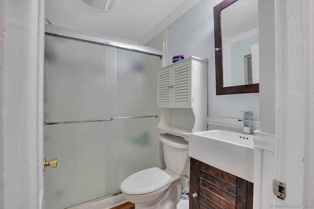 bathroom featuring ornamental molding, a shower stall, toilet, and vanity