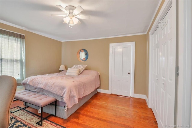 bedroom with crown molding, a closet, and light wood-style floors