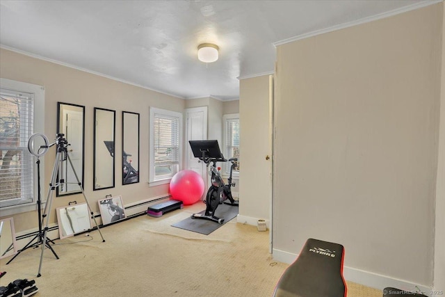 exercise area featuring a baseboard heating unit, carpet, baseboards, and crown molding