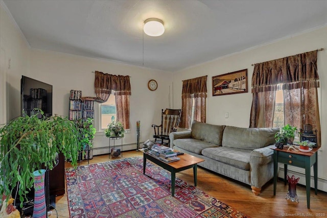 living room with ornamental molding, baseboard heating, and wood finished floors