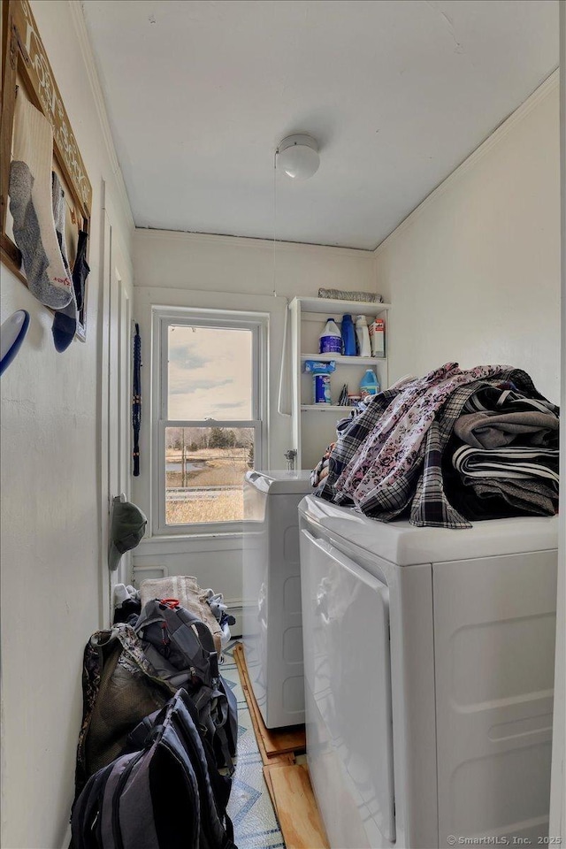 laundry room featuring washing machine and dryer, laundry area, crown molding, and light wood-style flooring