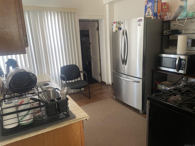 kitchen with appliances with stainless steel finishes and wood-type flooring