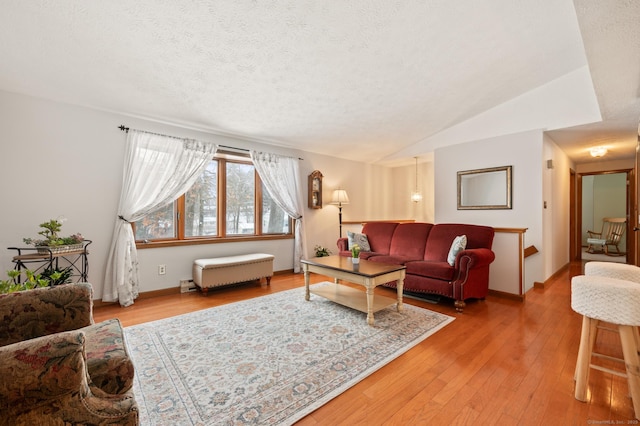 living room featuring a textured ceiling, hardwood / wood-style flooring, and vaulted ceiling