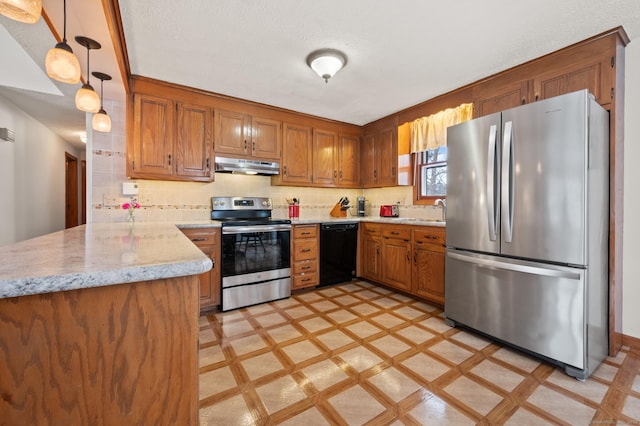 kitchen with kitchen peninsula, stainless steel appliances, decorative light fixtures, light stone countertops, and tasteful backsplash