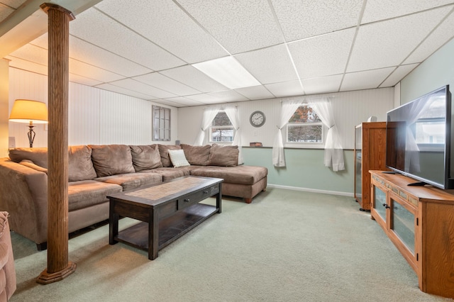 living room featuring a drop ceiling, carpet floors, and decorative columns