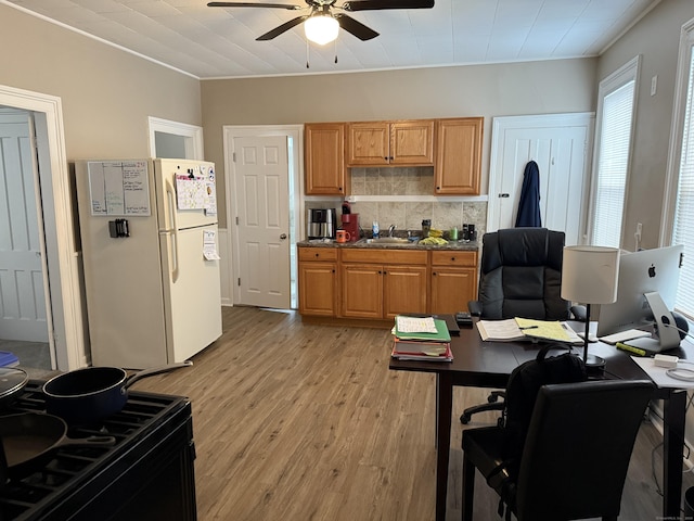 kitchen featuring a ceiling fan, dark countertops, tasteful backsplash, freestanding refrigerator, and light wood-style flooring