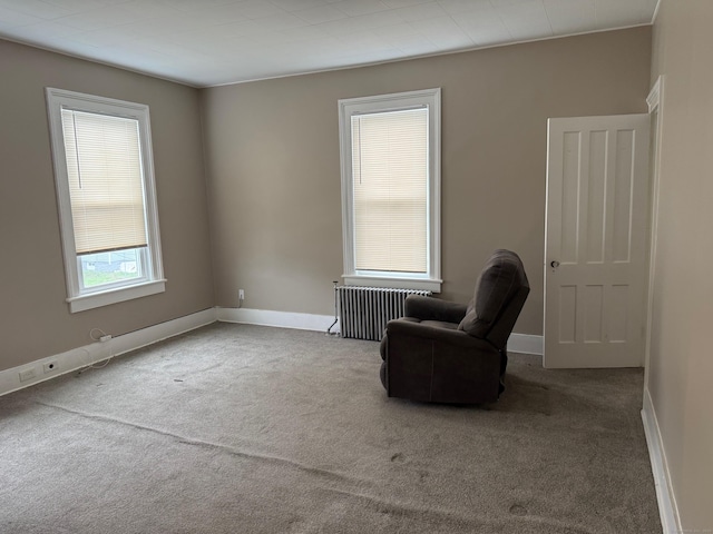 unfurnished room with radiator heating unit, baseboards, and carpet flooring