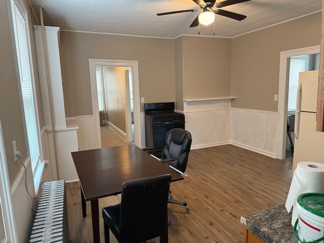 office area with a wainscoted wall, ornamental molding, a ceiling fan, and wood finished floors