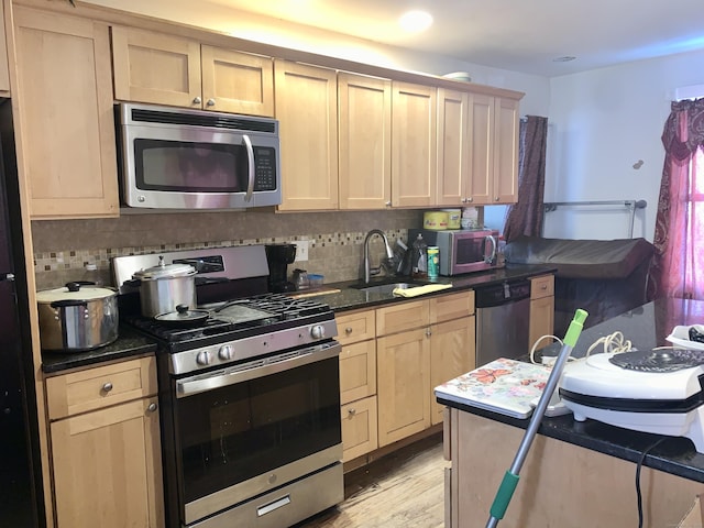 kitchen with sink, decorative backsplash, light hardwood / wood-style flooring, and stainless steel appliances