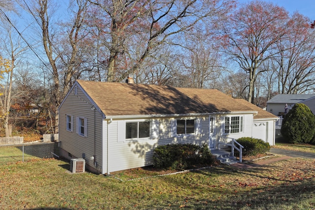 view of front of property with central AC and a front lawn