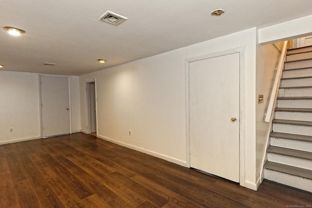 basement with stairs, dark wood-style floors, visible vents, and baseboards