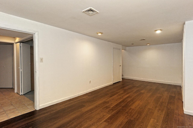 empty room featuring baseboards, visible vents, and wood finished floors