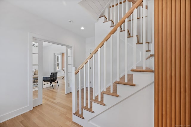 stairway featuring wood-type flooring and french doors