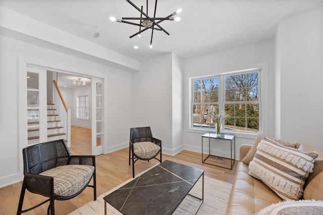 sitting room with a notable chandelier and light wood-type flooring