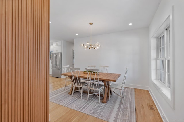 dining room with plenty of natural light, a chandelier, and light wood-type flooring