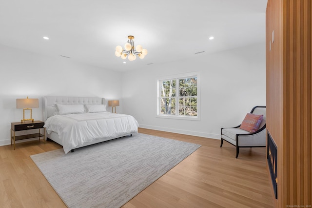 bedroom with an inviting chandelier and light hardwood / wood-style flooring