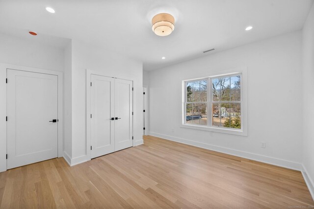 unfurnished bedroom featuring light wood-type flooring and a closet