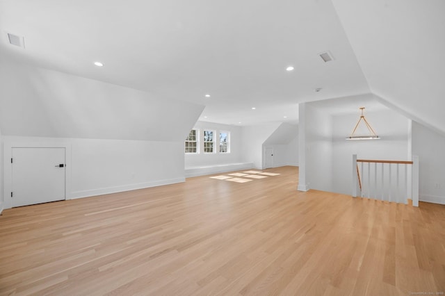 additional living space with lofted ceiling and light wood-type flooring