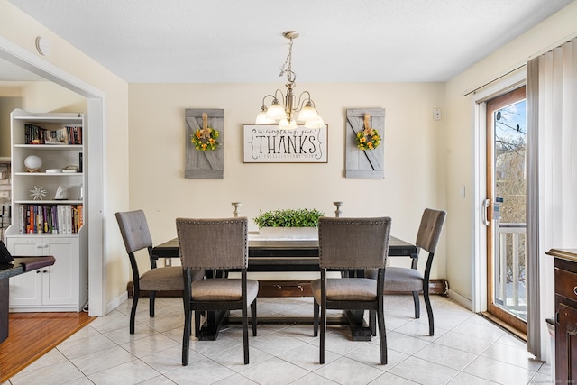 dining area with a notable chandelier, light tile patterned floors, and a textured ceiling