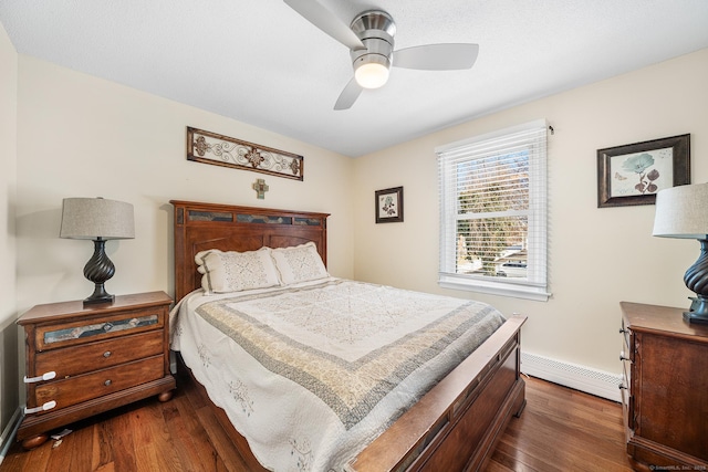 bedroom featuring a baseboard heating unit, dark wood-type flooring, and ceiling fan