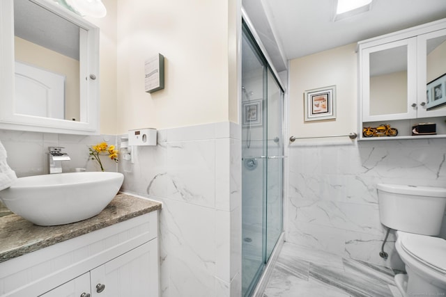 bathroom featuring vanity, toilet, an enclosed shower, and tile walls