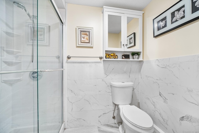 bathroom with toilet, an enclosed shower, and tile walls