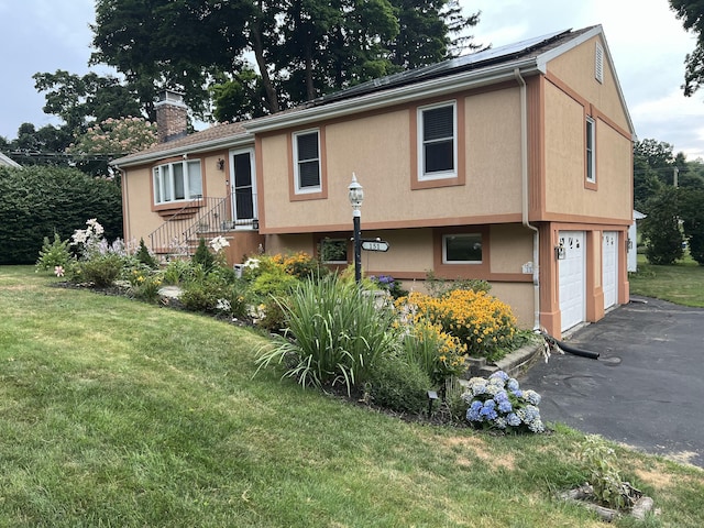 view of front of house with a garage and a front lawn