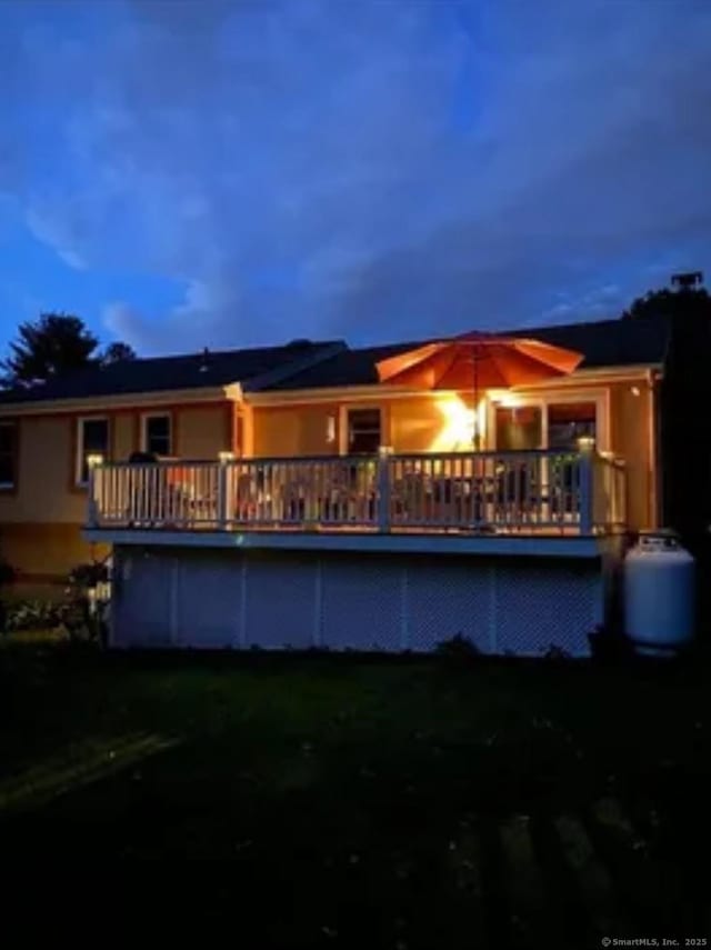 rear view of property featuring a wooden deck