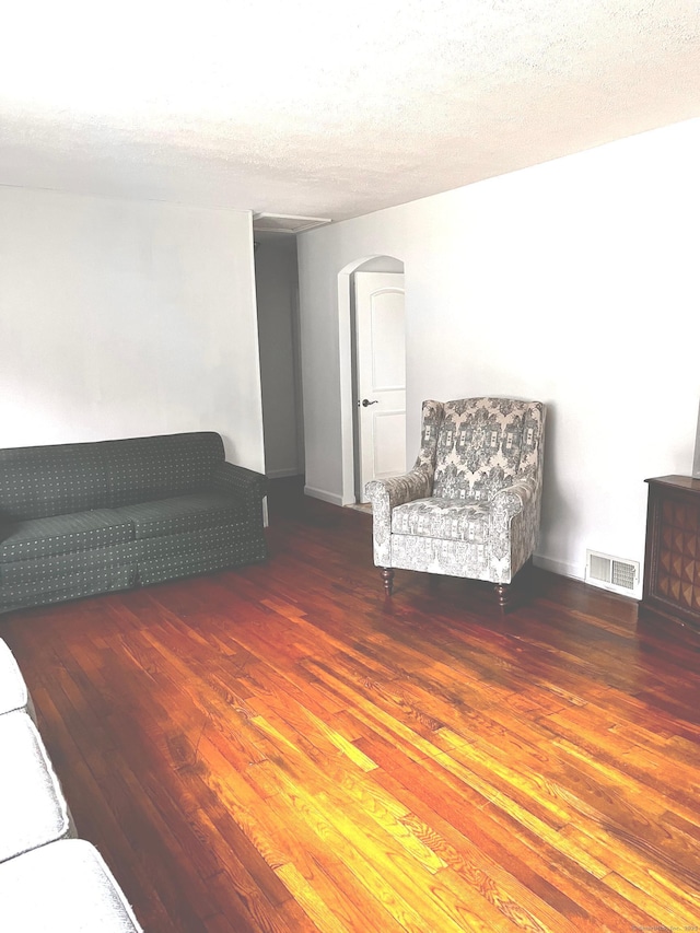 unfurnished room with dark wood-type flooring and a textured ceiling