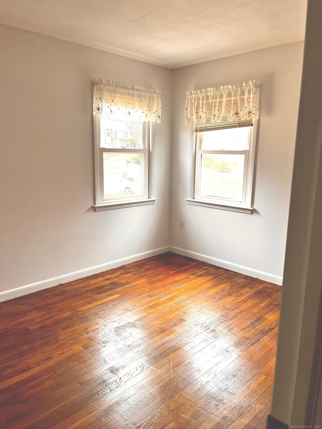 empty room with dark hardwood / wood-style flooring