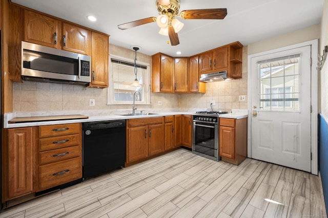 kitchen with sink, gas range, decorative light fixtures, dishwasher, and backsplash