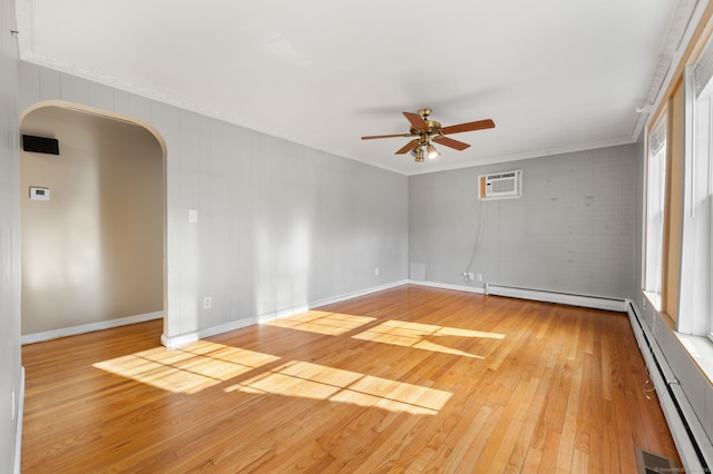 spare room with baseboard heating, ceiling fan, a wall mounted AC, and light hardwood / wood-style flooring