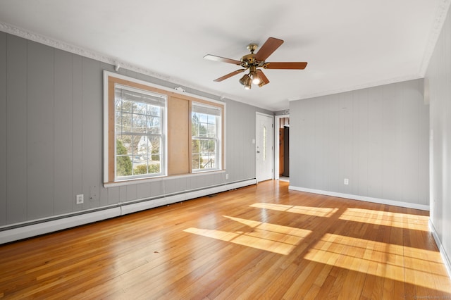 empty room featuring baseboard heating, ceiling fan, crown molding, and light hardwood / wood-style floors