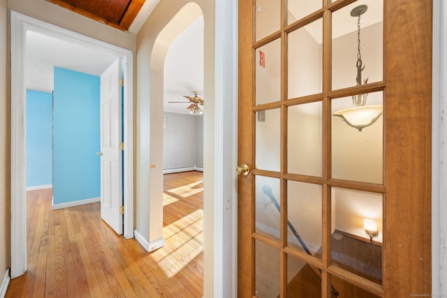 hallway with a baseboard heating unit and light hardwood / wood-style flooring