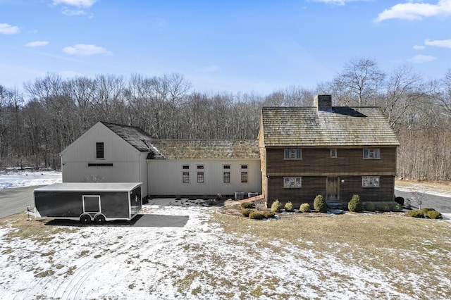 view of snow covered back of property