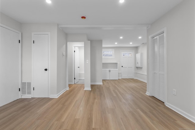 unfurnished living room featuring recessed lighting, light wood-style floors, visible vents, and baseboards